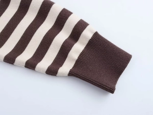 Close-up of brown and white striped knit sweater with ribbed cuff detail