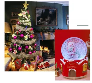 Close-up of a festive Christmas snow globe with Santa and a decorated tree ornament