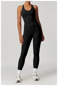 Dettaglio del top da yoga nero con incrocio e leggings a vita alta in tessuto elasticizzato