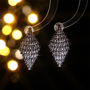 Macro shot of geometric diamond-shaped earrings with sparkling green rhinestones