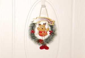Detailaufnahme vom Weihnachtskranz mit Tannennadeln, Beeren und einer Rentierpuppe