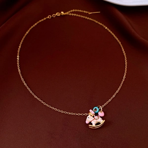 Detailed top view of gold carousel rocking horse pendant with pink and blue enamel