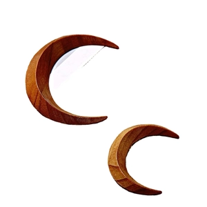 Handcrafted crescent moon hair fork in natural brown wood with detailed grain texture