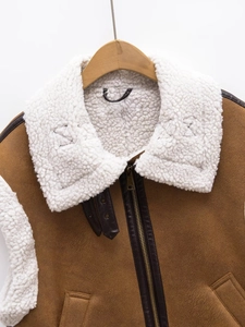 Close-up of brown suede vest featuring white faux shearling collar and metal zipper