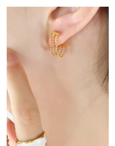 Détail de boucles d'oreilles pompon à perles dorées multicouches sur mannequin raffiné