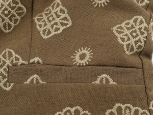 Détails de broderie ethnique et motifs géométriques sur tissu marron de qualité