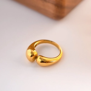 Macro shot of polished gold teardrop ring showing high-gloss finish and adjustable band