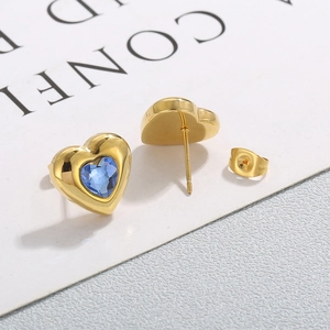 Vista macro di orecchini a cuore blu con base placcata in oro e dettagli della chiusura