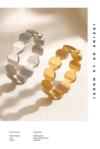 Polished geometric bead-edge rings in gold and silver finish on white textured fabric