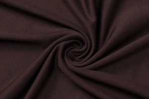 Detailed macro view of dark brown knitted fabric showing fine texture and elasticity