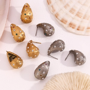 Detail of vintage matte 18K gold and silver waterdrop earrings with colorful zircons