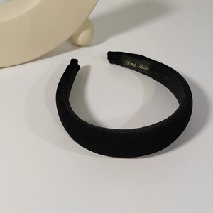 Detail of handmade label on a black velvet padded headband for a luxury finish