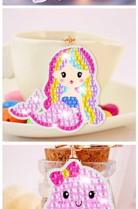 Detail of DIY diamond painting keychains in mermaid and unicorn shapes with colorful rhinestones
