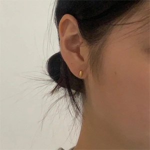 Minimalist 925 sterling silver oval bean stud earrings with polished gold finish on ear