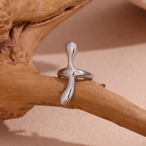 Artistic detail of liquid metal silver ring displayed on weathered wood texture