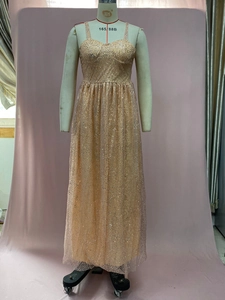 Détail d'une robe de soirée rose à paillettes avec bretelles fines et tissu en tulle