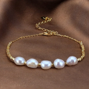 Elegant gold S925 silver bracelet featuring five baroque pearls on luxury silk background