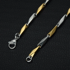 Close-up of dual-tone twisted chain link necklace with lobster clasp on leather