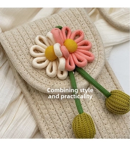 Close-up of handmade woven straw crossbody phone bag with 3D fabric flower details
