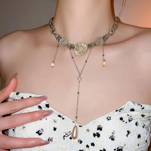 Detail of luxury gold choker with pearls, crystals and amber water-drop tassels on model