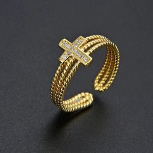 Macro shot of gold-plated multi-layer cross ring with sparkling zircon stones