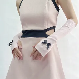 Pink rib-knit arm sleeves with black satin bows and pearl charms for a sweet Lolita style