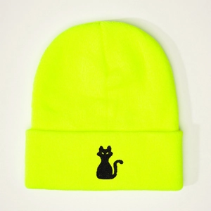 Détail de la broderie chat noir sur un bonnet en maille vert fluo avec bord à revers
