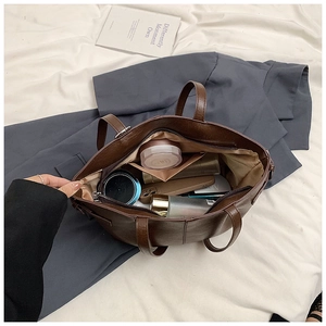 Deep brown faux leather tote interior showing large storage space and beige lining