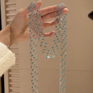 Elegant long silver mesh necklace featuring light blue crystals for a chic look