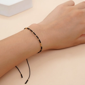 Bracelet d'amitié minimaliste fait main avec perles noires et accents dorés élégants