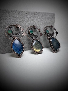 Detail of handmade vintage moon pendants with labradorite and star copper wire wrap