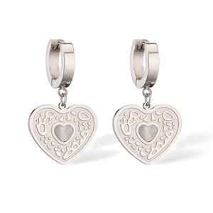 Detail of silver hoop earrings with textured heart charms and small heart cut-outs