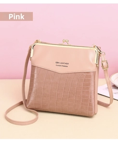 Close-up of pink crossbody bag featuring faux crocodile texture and gold metal clasp