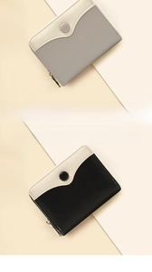 Detail of short leather wallet showing fine stitching, snap closure and metal zippers