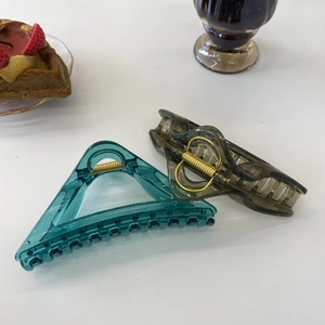 Detailed view of matte transparent resin hair claws in triangular and wave shapes