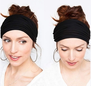 Detail view of a black wide knotted headband showing the fabric texture and sports fit