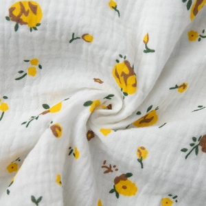 Détail du tissu en coton blanc à imprimé floral jaune et texture gaufrée de la robe d'été