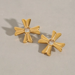 Close-up of gold cross stud earrings featuring a square zircon stone inlay and metal polish
