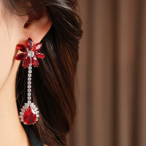 Detail of flower-shaped silver earrings with red and white zircon water drop pendants