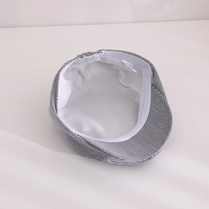 Détail de la casquette bébé montrant la doublure respirante et l'étiquette de taille
