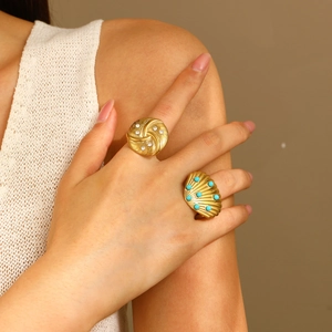 Detail of vintage gold textured rings with white crystals and turquoise blue beads