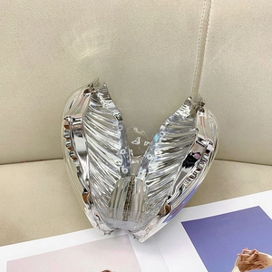 Polished silver heart-shaped metal clutch bag with a reflective mirror finish
