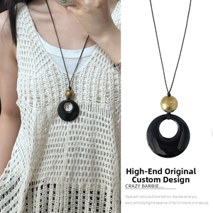 Detail view of ethnic retro long necklace with black resin ring and gold bead