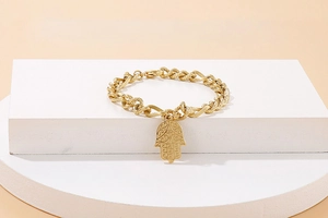 Dettaglio macro del bracciale a catena ritorta dorata con ciondolo a mano di Fatima