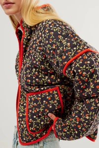 Detail of dark blue floral quilted jacket with red piping and vintage flower pattern