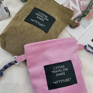 Detailed texture of corduroy fabric on olive and pink crossbody bags with woven straps