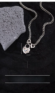 Detail of silver heart locket necklace with iridescent gem and copper-silver plating