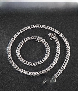 Close-up of polished 8mm stainless steel Cuban link chain necklace and bracelet set