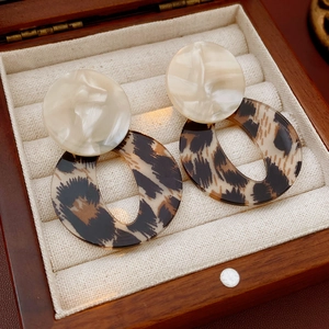 Dettaglio di orecchini vintage leopardati presentati in una scatola di legno