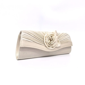 Detailed macro view of the handmade satin rose and pleated fabric on cream evening clutch bag